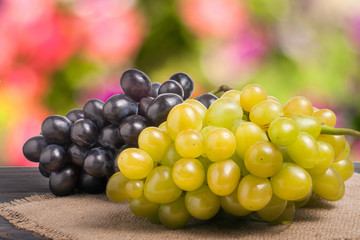 Blue and green grapes on wooden table with a blurred background