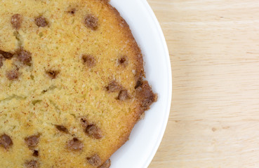 Apple spice muffin top on a plate atop a wood table.
