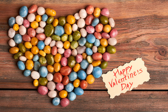 Colorful candy heart and card. Pile of sweet sea pebbles. Add sugar to your relationship.