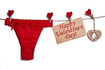 Red lingerie on white background. Card and hearts on rope. Styte combined with passion.