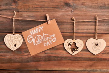 Wooden hearts on rope. Greeting card and clothespin. Handmade congratulation on Valentine's Day.