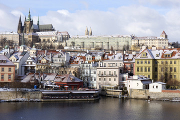 Obraz premium Snowy freeze Prague Lesser Town with gothic Castle above River Vltava, Czech republic