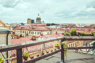 SAINT-PETERSBURG, RUSSIA - august 2016: Scenic view on famous historical golden dome of  Isaac's Cathedral and old city from roof. Summer cityscape over the rooftops. Editorial use only.
