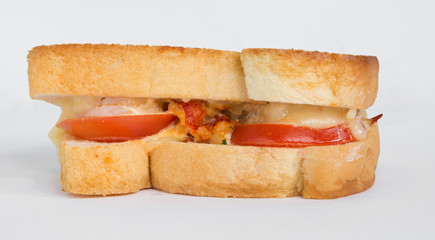 A cheese, prawn, seafood and tomato grilled sandwich, isolated on a white background