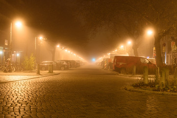 Fototapeta premium leere straße nachts im nebel in berlin empty road at night in fog in berlin