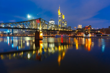 Picturesque view of Frankfurt am Main skyline and Eiserner Steg bridge with mirror reflections in...