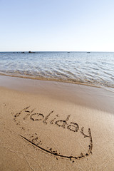 The word Holiday in sand