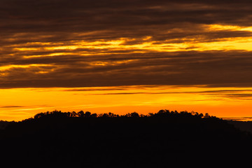 Breathtaking sunset over mountain and silhouette landscape with tree shadow