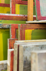 Silk screen printing screens stored in a wooden rack ready for printing.