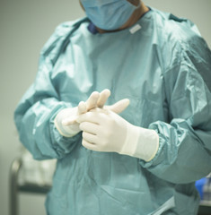 Surgeon putting on gloves