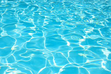 Beautiful ripple water surface with sun reflection in swimming pool