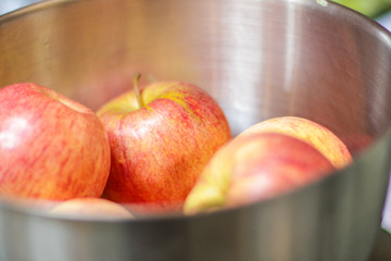 Fresh red apples in the bowl on the table