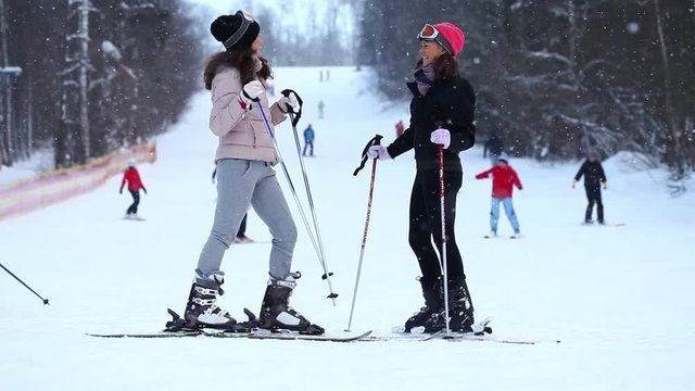 Young twins with ski stand at the hill