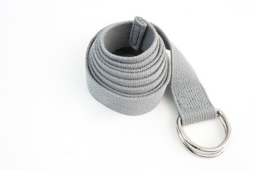 Coiled yoga belt on white background.