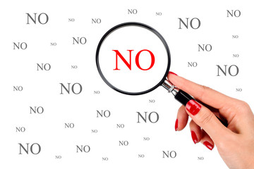 Woman with red manicure holding a magnifier over the word No isolated on white background