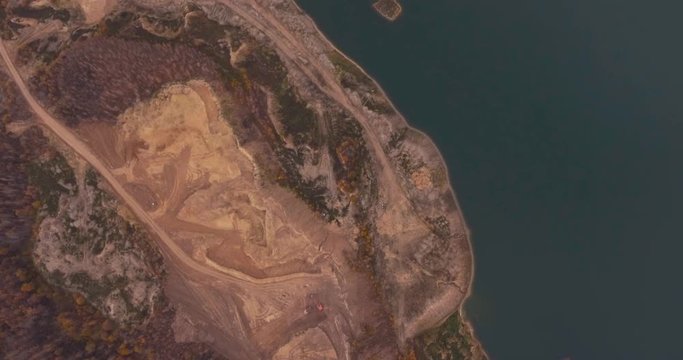 Flight to drone on sand quarry with heavy machinery