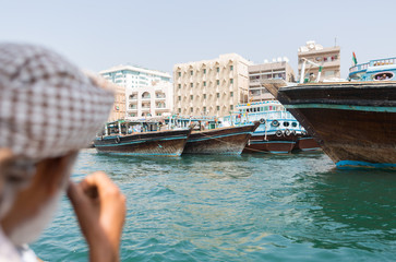 Dubai, United arab emirates, 02/02/2016, An arabic man looking over to deira on a boat on dubai creek, near deira and bur dubai.