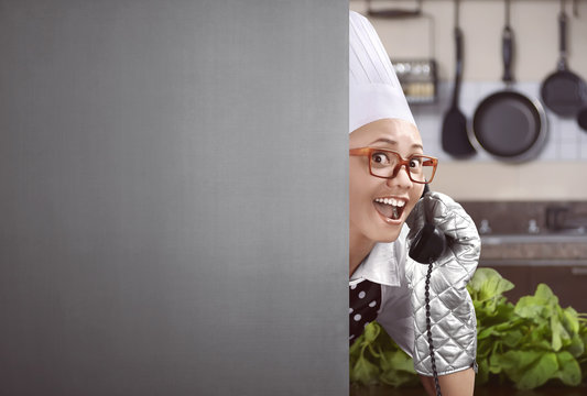 Happy asian female chef lifted up the phone