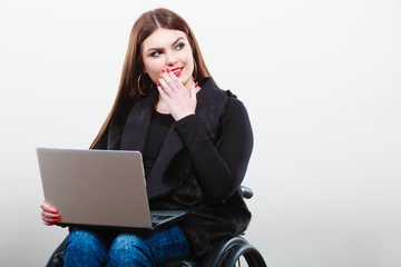 Disabled woman with laptop on wheelchair.