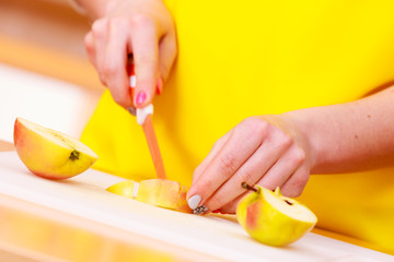 Woman housewife in kitchen cutting apple fruits