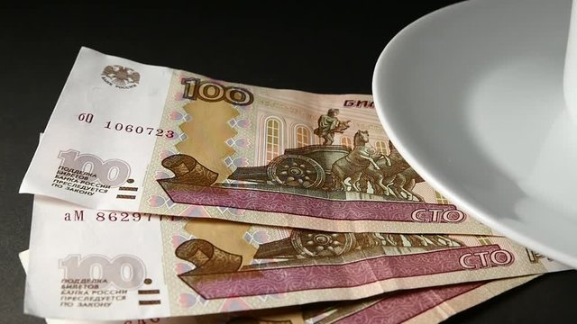 Cup Of Coffee And Saucer And Banknotes One Hundred Rubles. Slow Motion