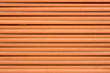 Orange painted corrugated metal sheet roller door texture as the creative background