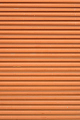 Orange painted corrugated metal sheet roller door texture as the creative background