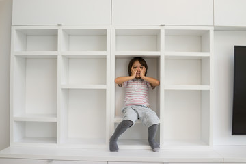 Fototapeta na wymiar Child in shelf inside living room
