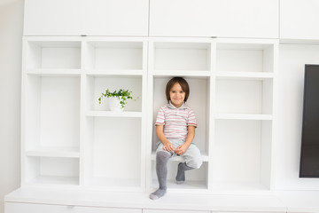 Fototapeta na wymiar Child in shelf inside living room