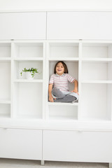 Child in shelf inside living room