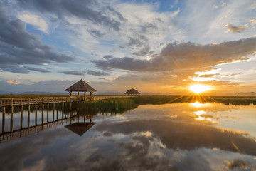 Fototapeta premium Wooden bridge laying on lake at sunset scenery