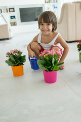 Kid taking care of plants and flowers at home