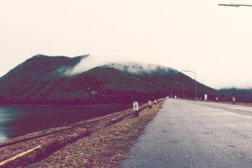 Road on the dam and background of  mountain mist. retro vintage