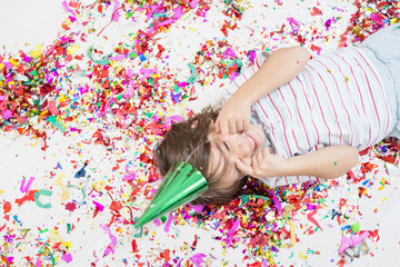 Obraz na płótnie Canvas Young boy blows out confetti, isolated on white background