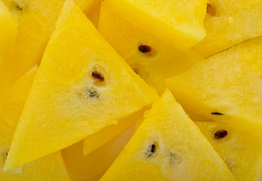 pile of portion cut yellow watermelon on white background