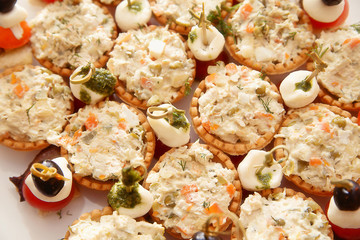 many tartlets with russian salad on buffet table