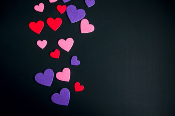 Colored hearts over black background.