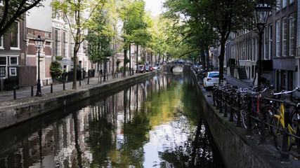 Amsterdam morning in center city - street with bicycles and cars on canal, Autumn, Netherlands