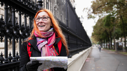 Yong woman tourist with red hair and glasses looking map in Vienna near Neue Burg, Austria