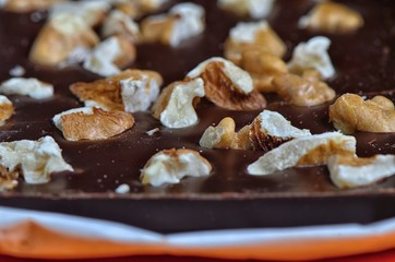 Chocolate and walnuts  /  Dark chocolate with walnuts. Focus is on the second row of nuts.