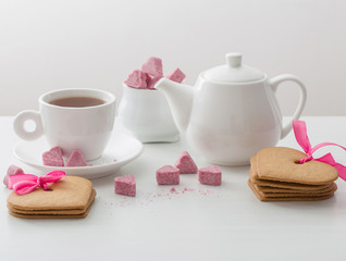 Granulated pink sugar  in the shape of heart and cup of tea  on