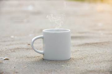 White coffee mug on the beach.