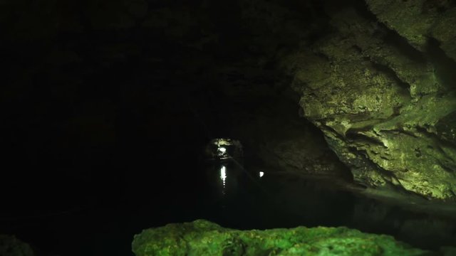 Inside the dark and deep cave lit lantern. Inside the cave pond