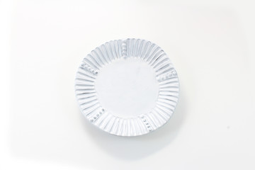 Hand made white porcelain plate with fluted rim, isolated on white
