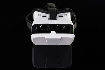 Virtual reality VR glasses or goggles isolated on black background with mirror reflection. Closeup product photograph. Computer simulated reality concept image with copy space