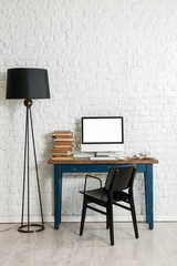 white brick wall concept and black lamp and black chair with computer interior decoration