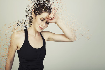 young woman  tired on bg disintegrate into particles effects