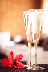 Two glasses of champagne with red flower in a spa lounge. Spa ti