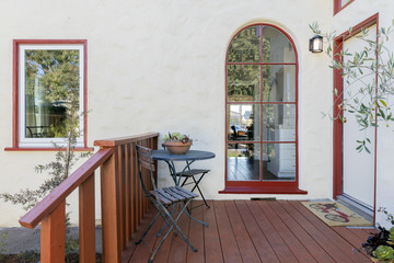 Round top Window with wooden deck and seating arrangement.