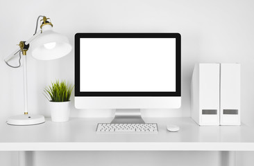 Blank screen computer, lamp and table folder over white background